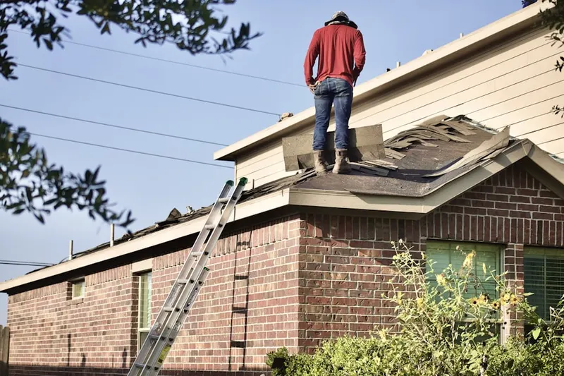 Professional roofer working on a residential roof in Fairview Village